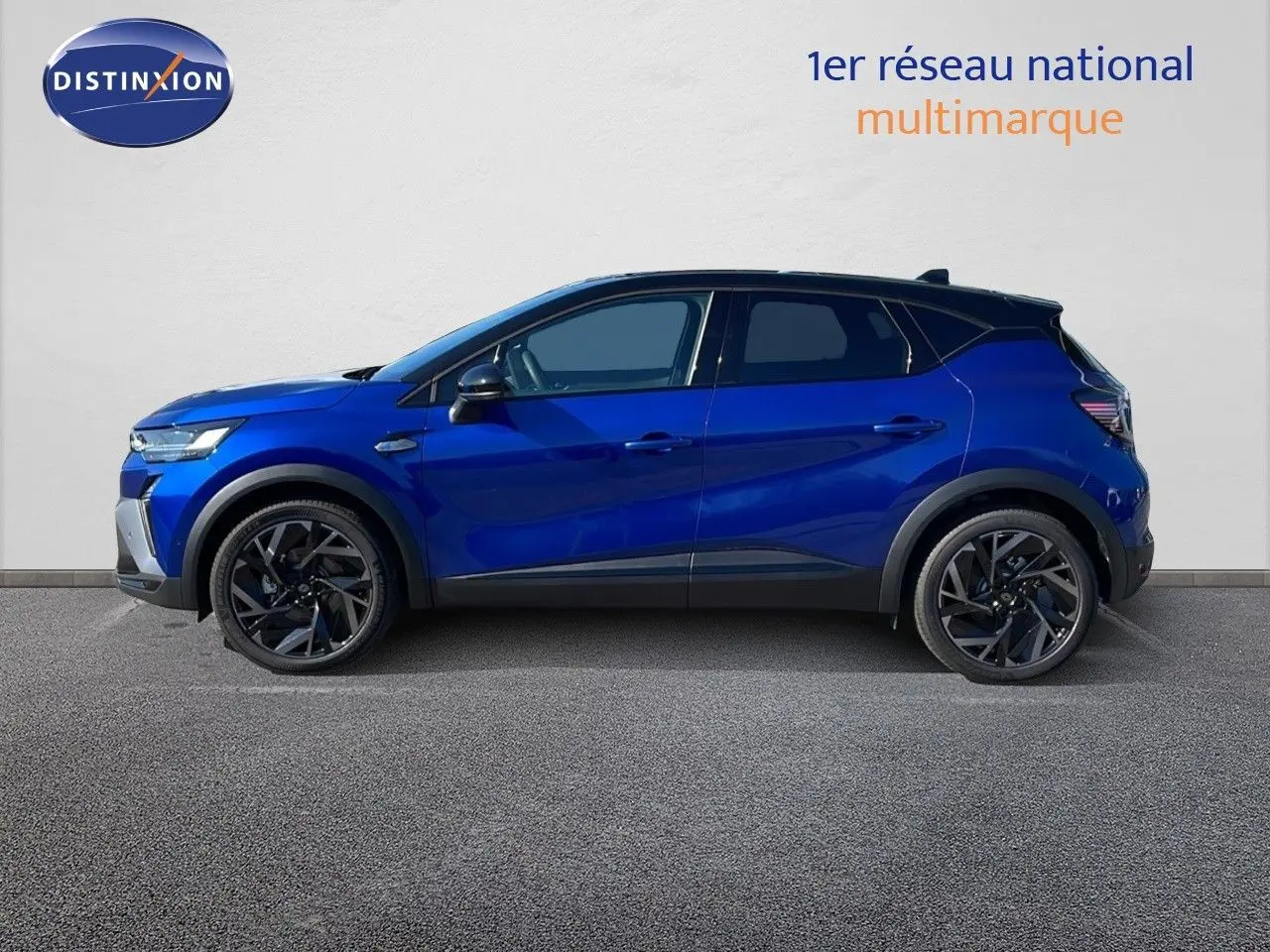 Profil droit du Renault Captur E-Tech hybride 2025 bleu Iron Metal avec toit noir et jantes noires distinctives.