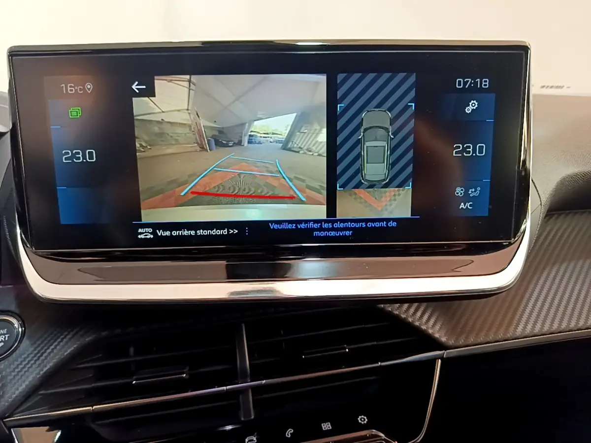 Écran tactile intérieur du Peugeot 2008 gris clair 2021 affichant la caméra de recul et l’aide au stationnement arrière.