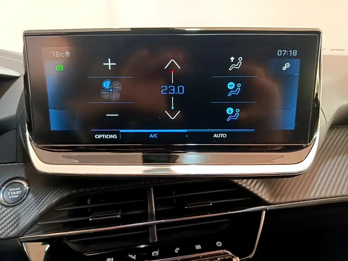 Écran tactile central affichant la climatisation à 23°C dans l’habitacle d’une Peugeot 2008 gris clair, vue de face.