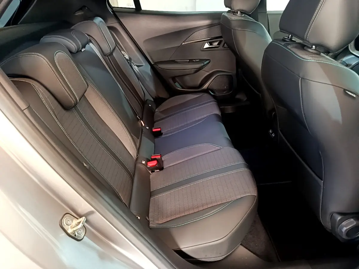 Vue côté droit de l'habitacle arrière du Peugeot 2008 gris clair, avec banquette trois places et finitions tissu-cuir.