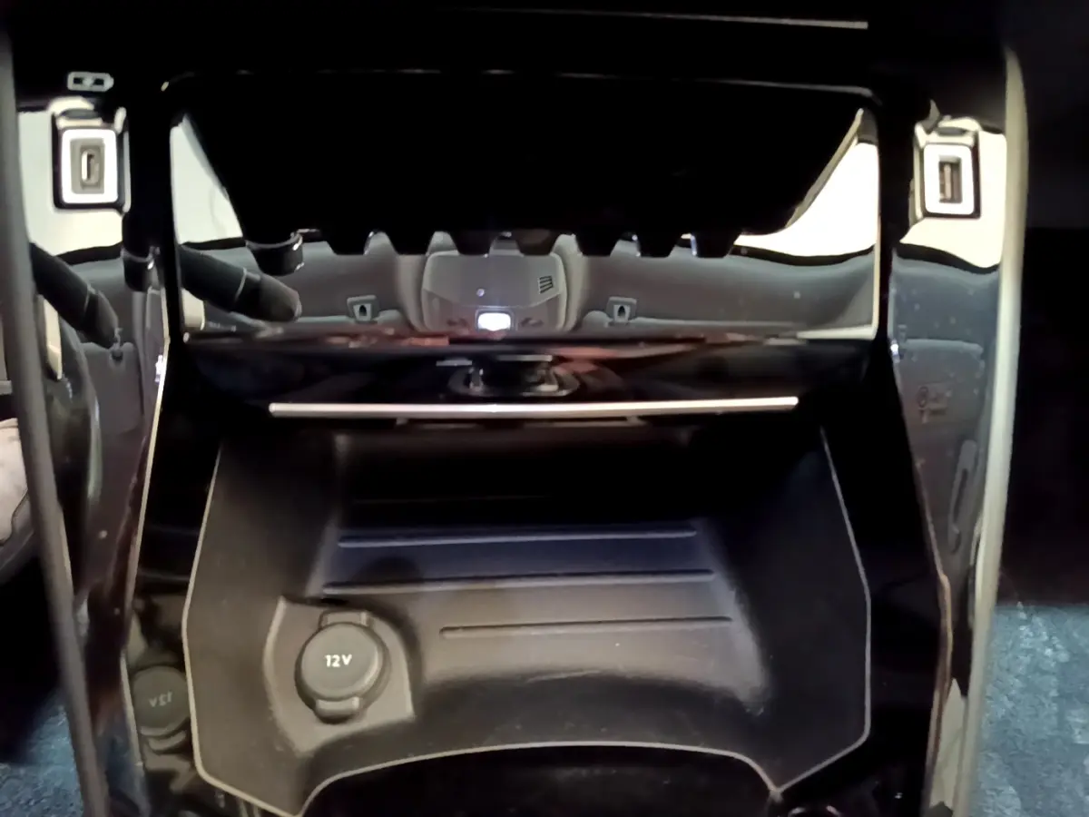 Gros plan sur la prise 12V dans la console centrale noire du Peugeot 2008 gris clair, version Allure Business 2021.