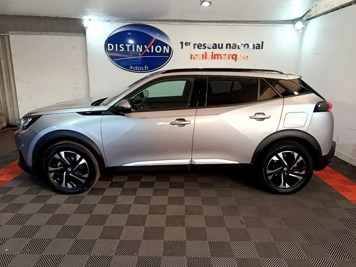 Peugeot 2008 gris clair vue de profil côté gauche, avec jantes noires et toit noir contrastant.
