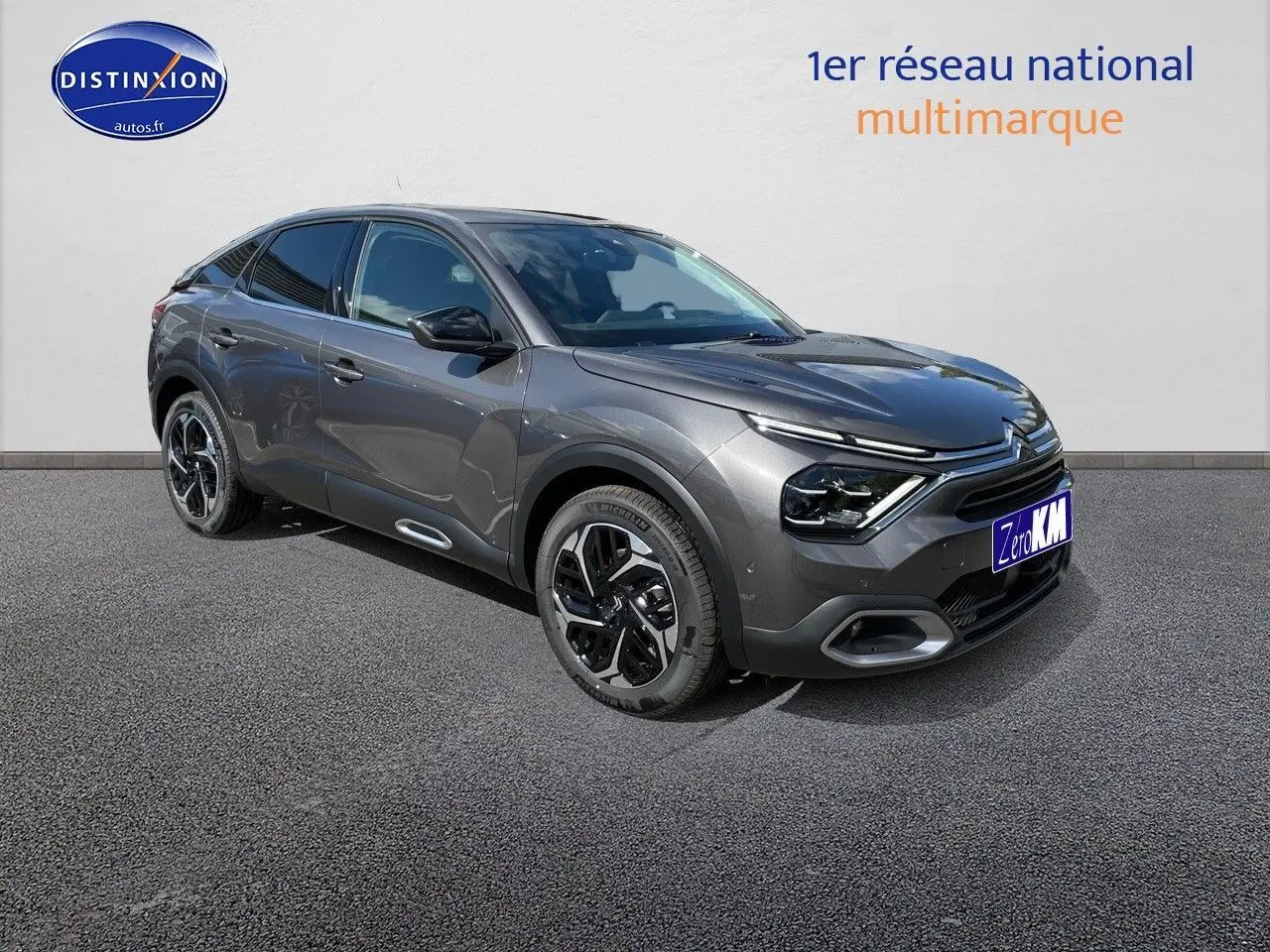 Citroën C4 gris platinium métal en 3/4 avant droit, avec jantes bicolores et feux LED distinctifs.