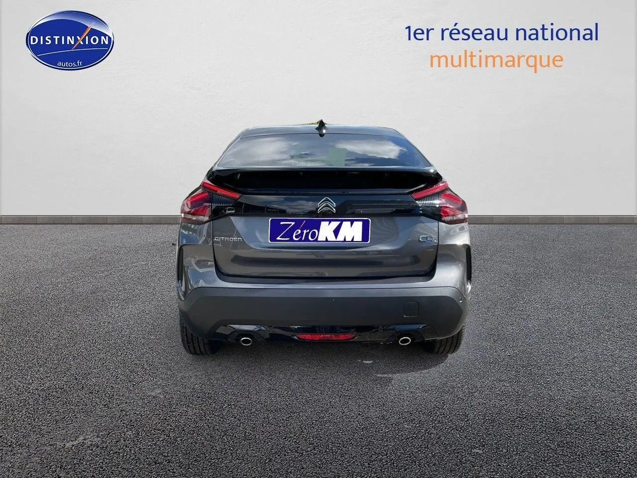 Vue arrière d'une Citroën C4 gris platinium métal 2024 avec feux LED et double sortie d'échappement visible.