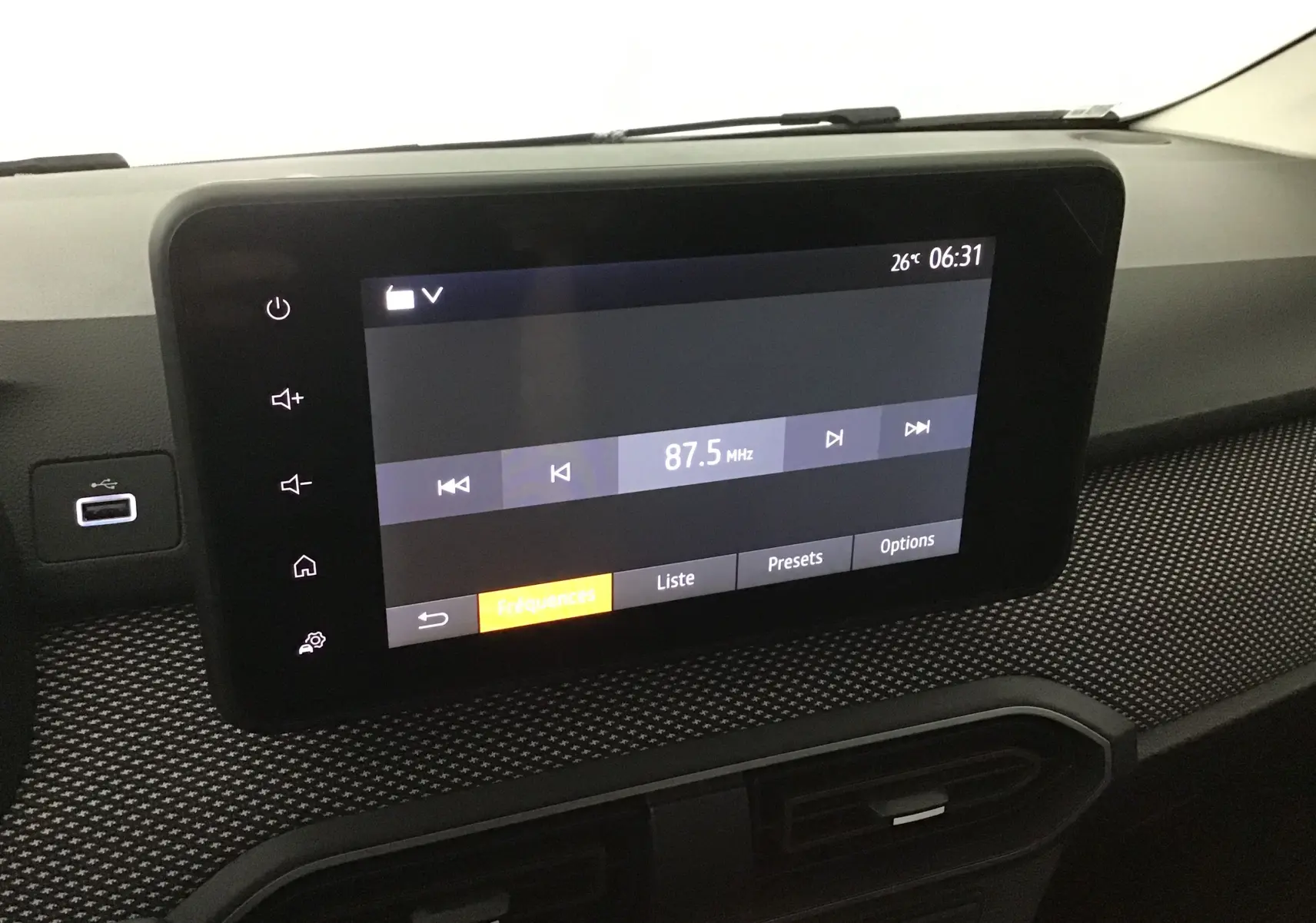 Écran tactile central affichant la radio à 87,5 MHz sur le tableau de bord du Dacia Sandero Stepway 2025 gris schiste