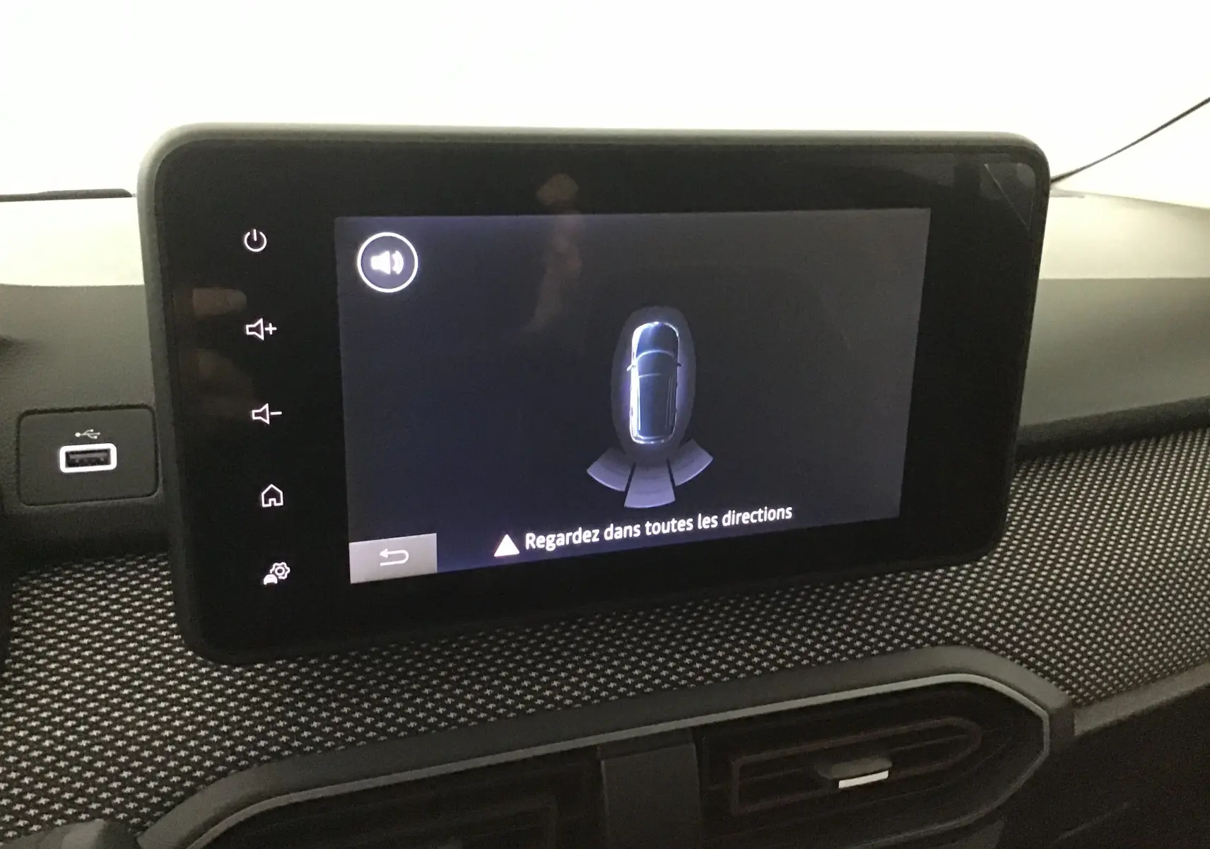 Écran tactile central du tableau de bord de la Dacia Sandero Stepway 2025 affichant l'alerte de détection d'obstacles.