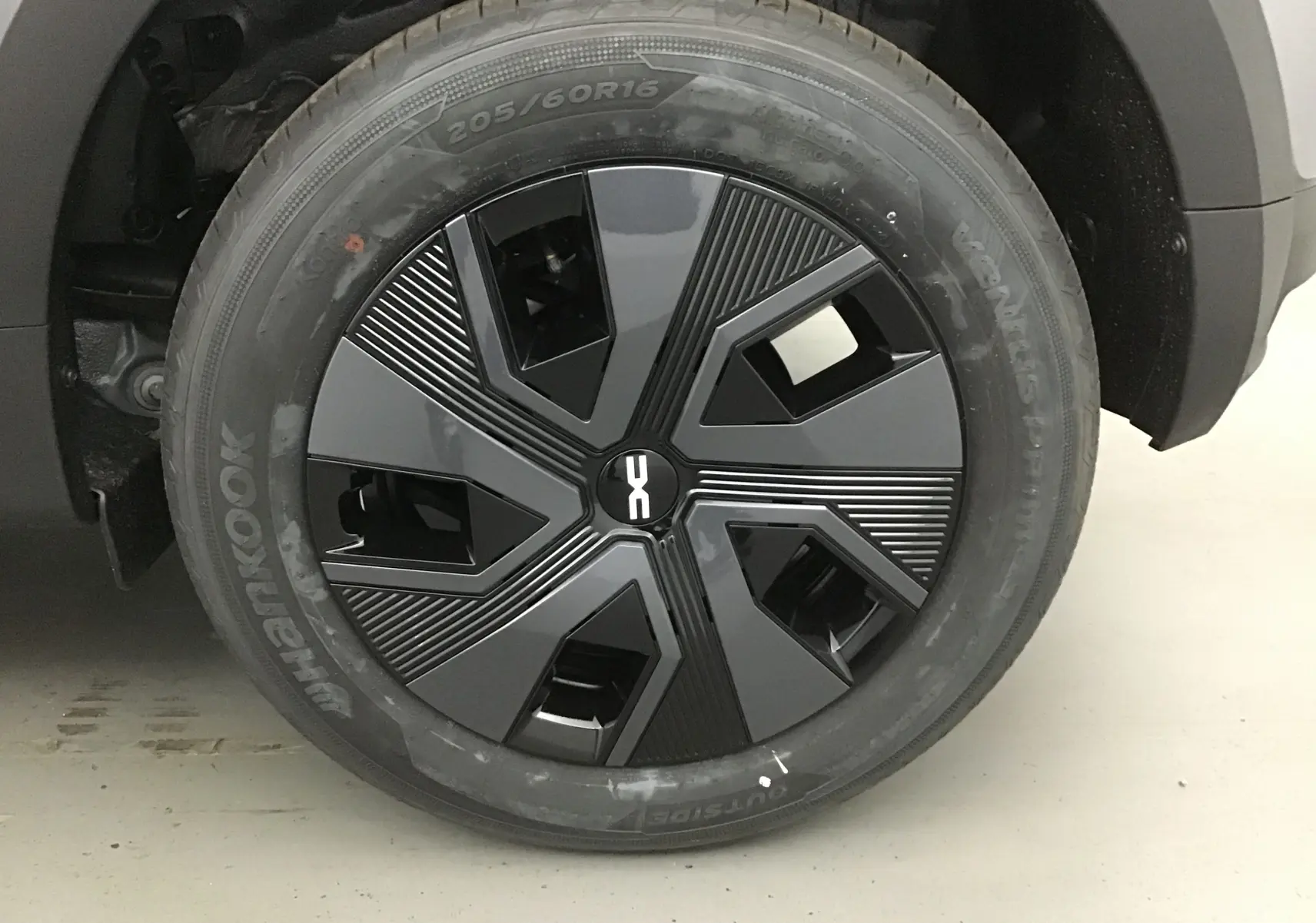 Gros plan sur la roue avant droite de la Dacia Sandero Stepway 2025 gris schiste avec jante noire au design moderne.