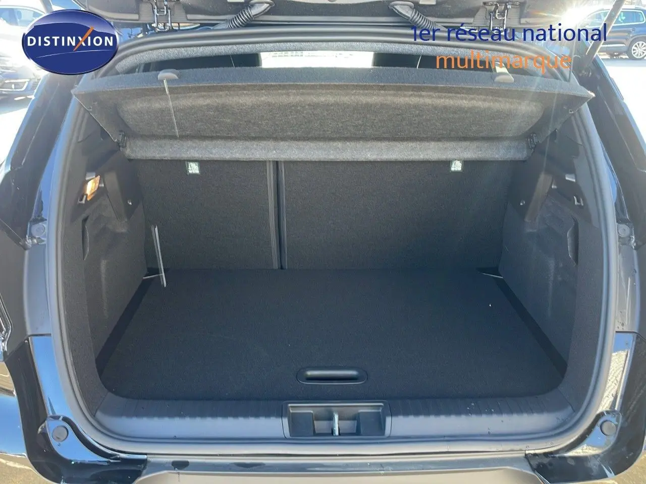 Coffre ouvert vu de l'arrière d'un Renault Captur noir étoile métal, montrant un espace de rangement vide et propre.