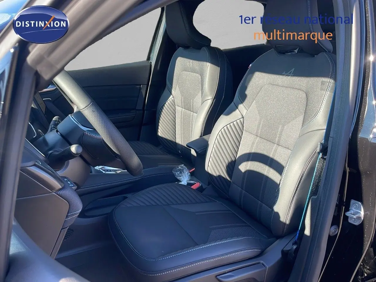 Vue intérieure côté conducteur du Renault Captur E-Tech hybride 2025 avec sièges noirs en cuir et tissu Alpine.