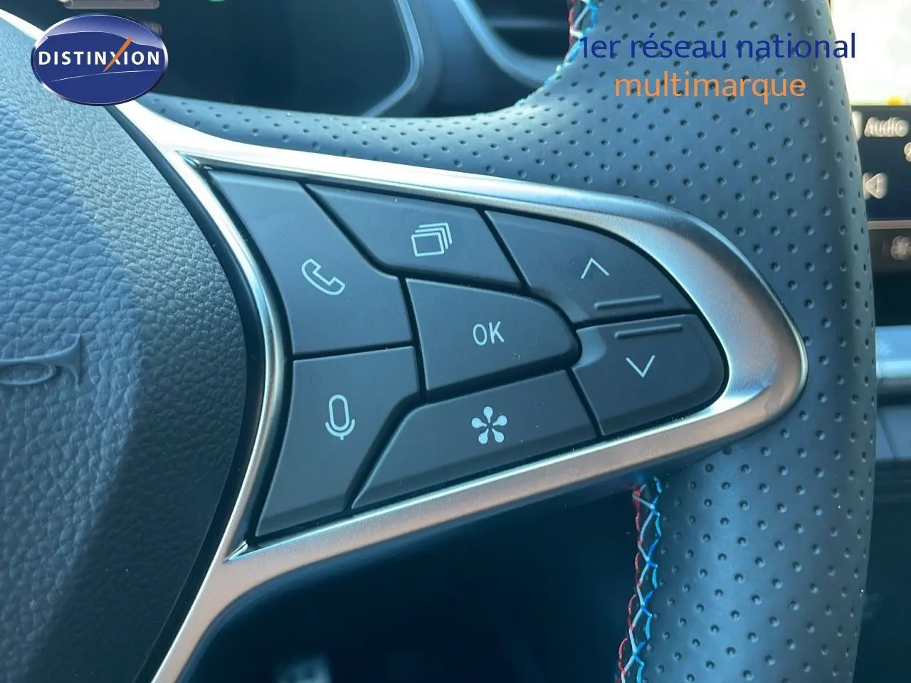 Gros plan sur les commandes multifonctions du volant perforé du Renault Captur E-Tech hybride noir étoile métal 2025.