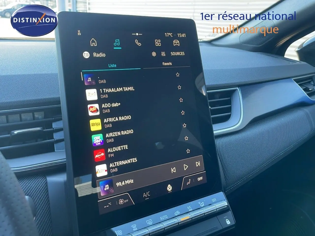 Vue rapprochée de l'écran tactile central du tableau de bord du Renault Captur noir étoile métal 2025, affichant les stations radio numériques.