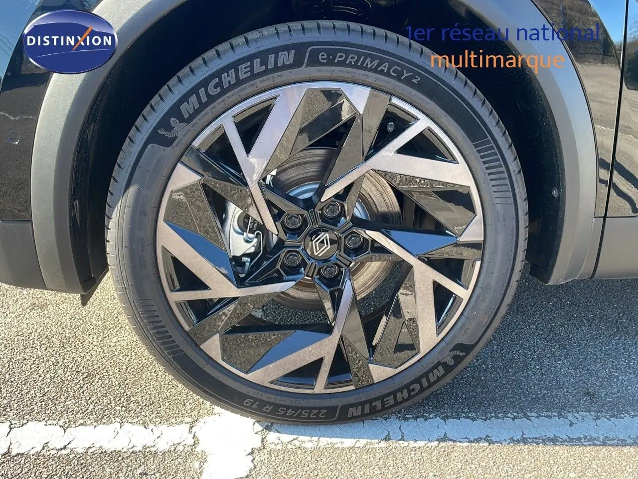Gros plan sur la roue avant gauche du Renault Captur noir étoile métal avec jante alu au design géométrique.