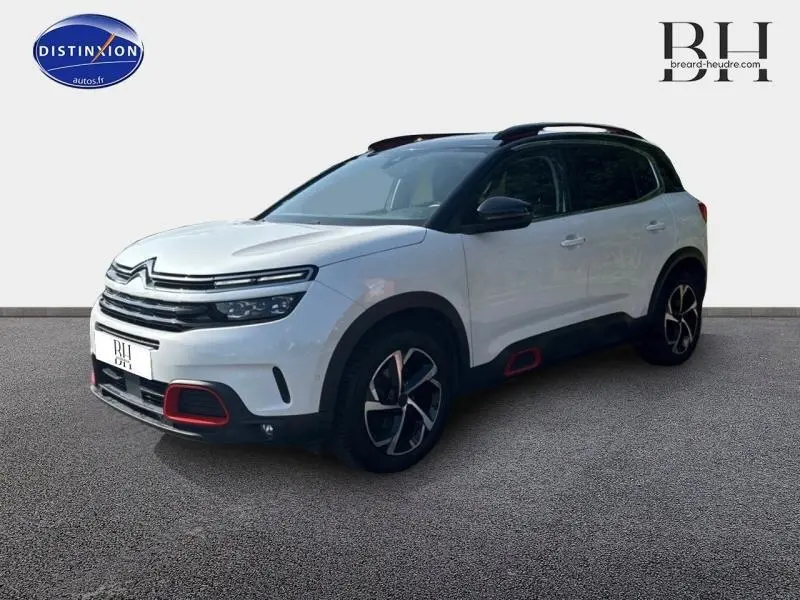 Citroën C5 Aircross blanc nacré en 3/4 avant droit avec détails rouges sur boucliers et jantes noires.