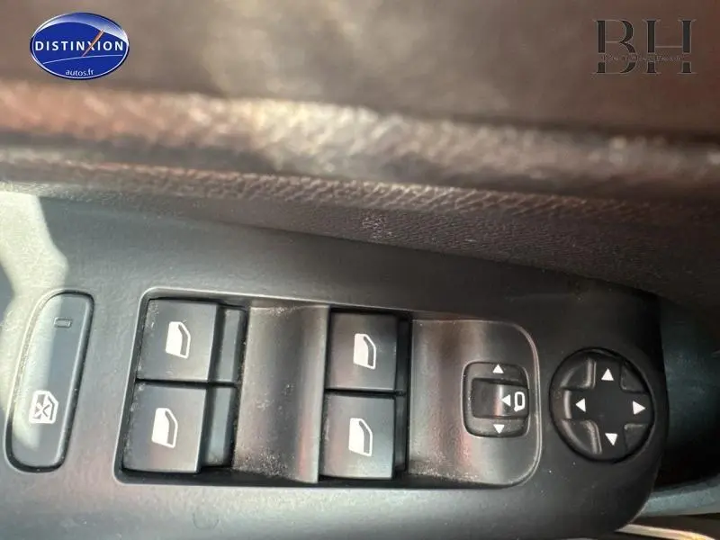 Gros plan sur les commandes de lève-vitres et réglage des rétroviseurs côté conducteur d'une Citroën C5 Aircross blanc nacré.