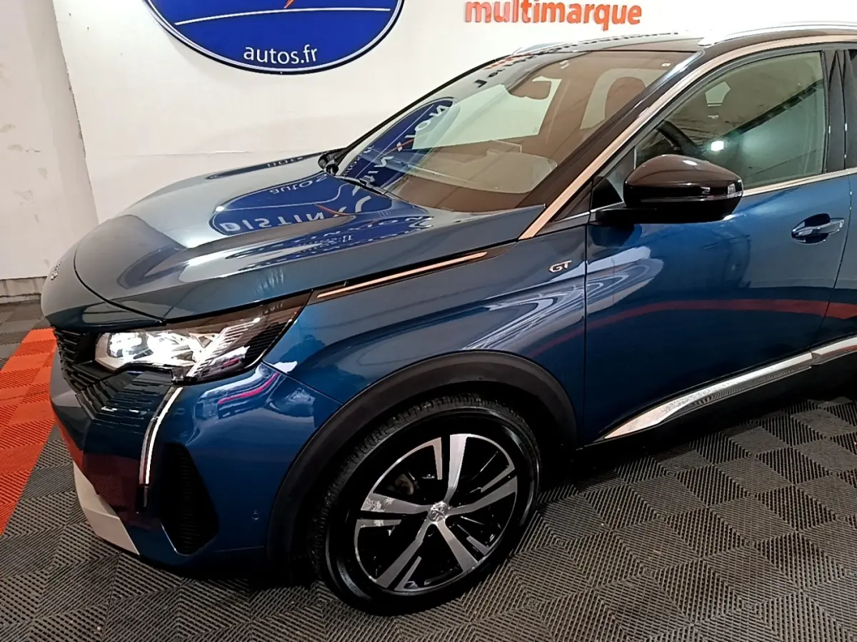 Vue 3/4 avant droit d’un Peugeot 3008 GT bleu avec phares LED et jantes alliage distinctives.