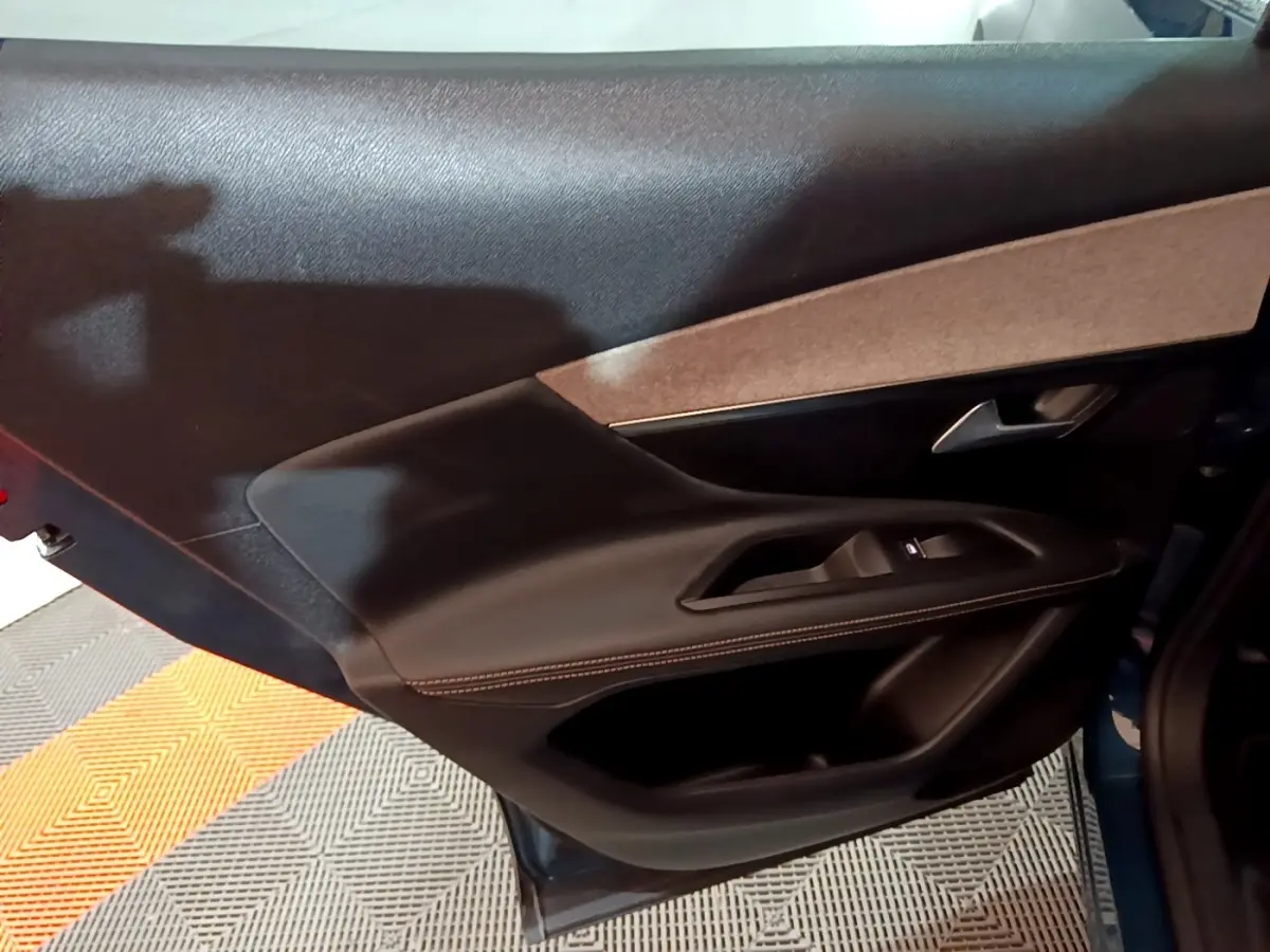 Vue intérieure du panneau de porte côté gauche en cuir noir avec surpiqûres contrastantes du Peugeot 3008 GT bleu 2021.