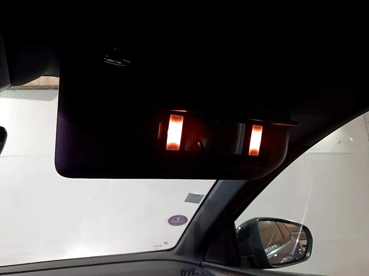 Vue intérieure côté droit du Peugeot 3008 bleu 2021, miroir de courtoisie avec éclairage allumé sur pare-soleil.