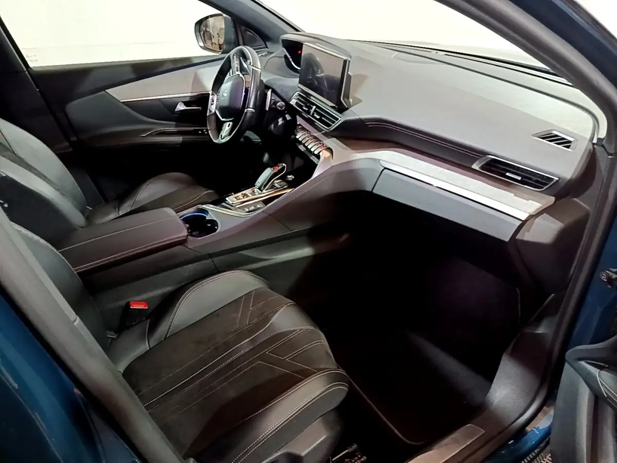 Vue intérieure côté conducteur du Peugeot 3008 bleu, avec sièges cuir noirs et tableau de bord moderne équipé d’un écran tactile.