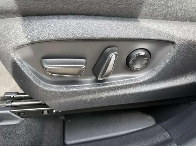Gros plan sur les commandes de réglage électrique du siège côté gauche du Toyota C-HR Hybride bleu persan 2024.