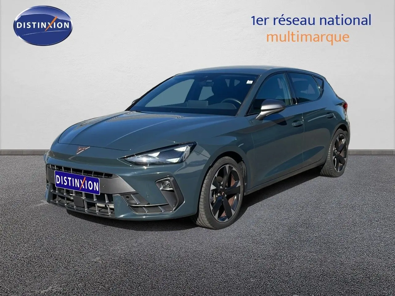 CUPRA Leon 1.5 eTSI 150CH DSG bleu Fjord en 3/4 avant droit avec jantes noires bicolores sur sol gris.