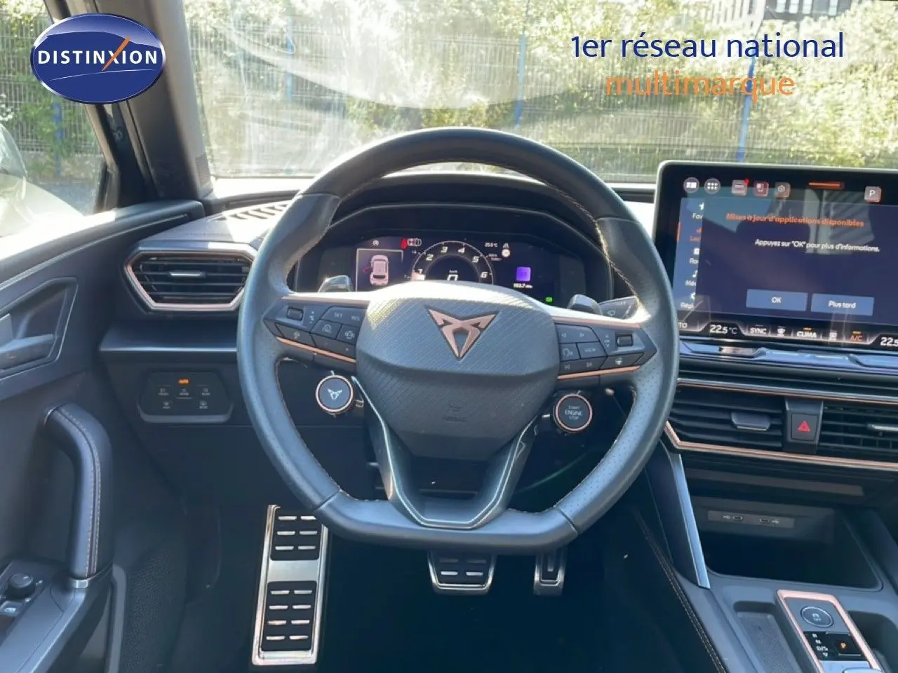 Vue intérieure centrée sur le volant cuir noir de la CUPRA Leon 2025 avec tableau de bord numérique et écran tactile.