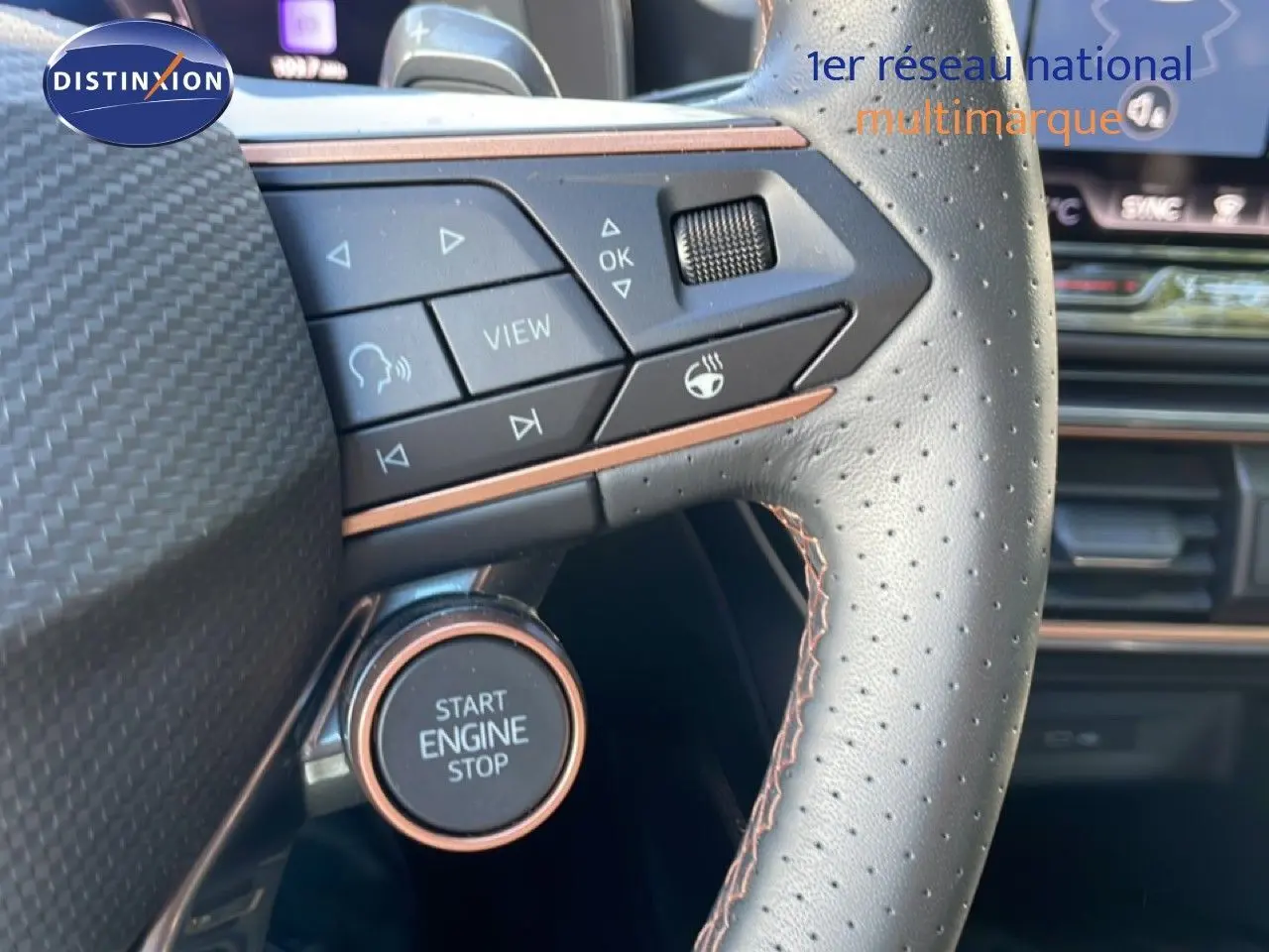 Gros plan sur le volant en cuir perforé avec commandes intégrées et bouton start/stop de la CUPRA Leon bleu Fjord 2025.