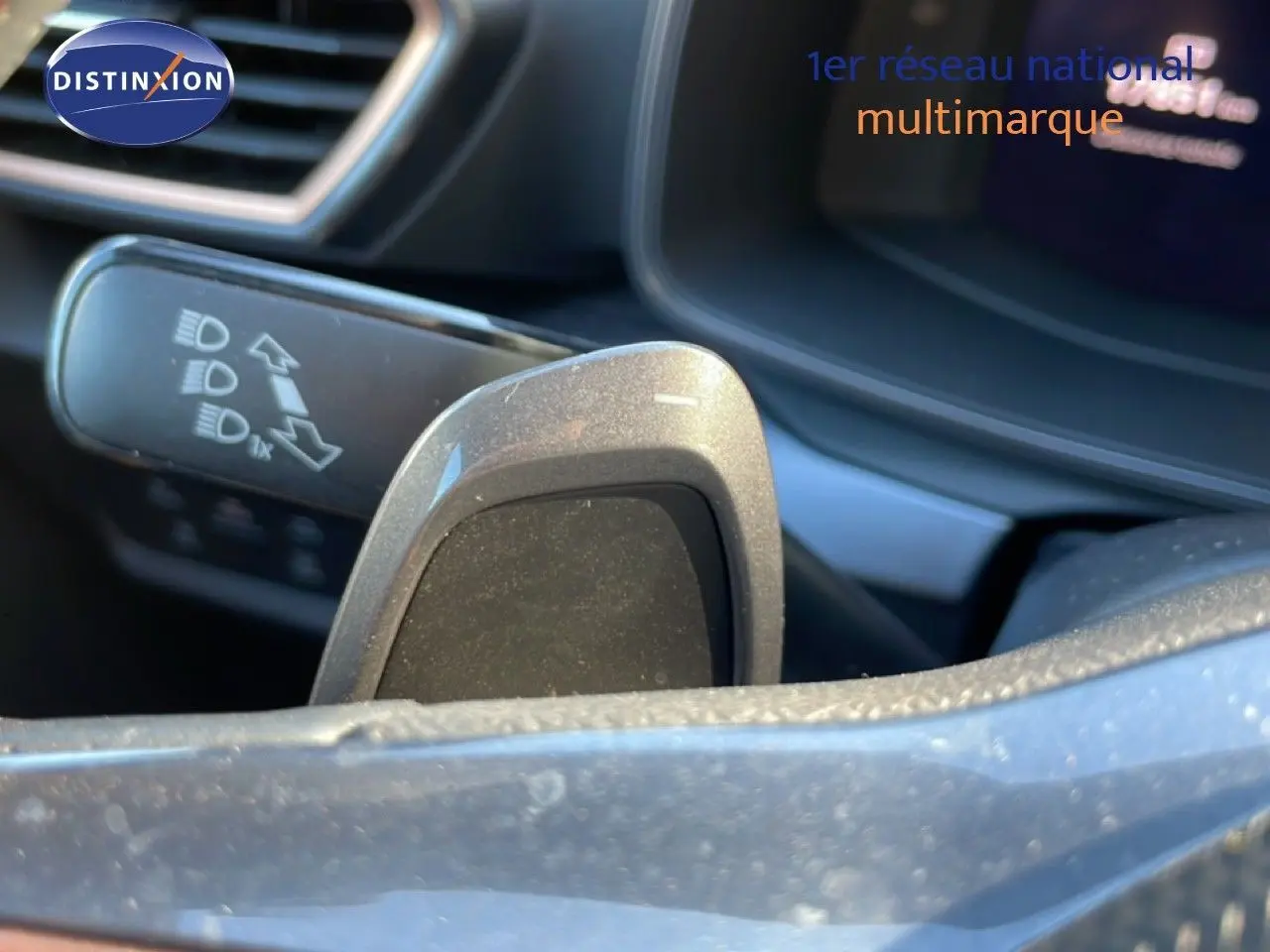Gros plan sur la palette de changement de vitesse côté droit du volant d'une CUPRA Leon bleu Fjord, intérieur moderne.
