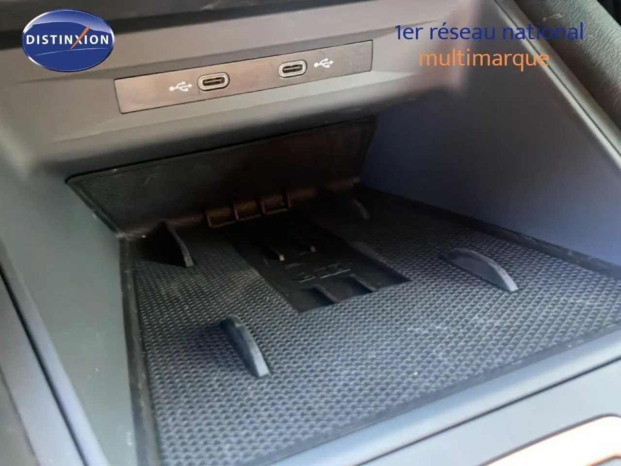 Gros plan sur la console centrale d’une CUPRA Leon 2025, montrant les ports USB et un espace de rangement noir.