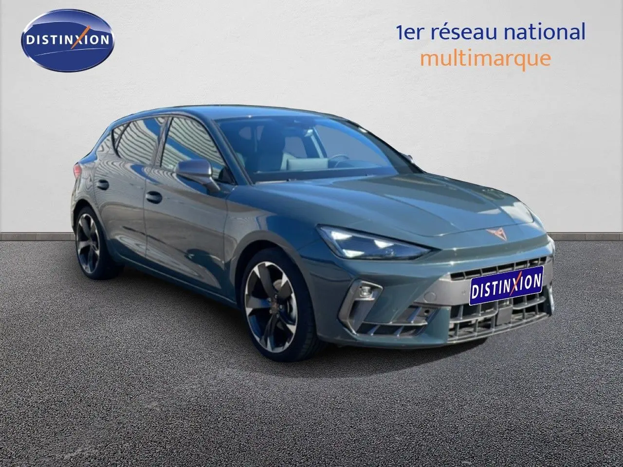 CUPRA Leon 1.5 eTSI 150CH bleu Fjord en 3/4 avant droit, avec jantes alliage et calandre distinctive.