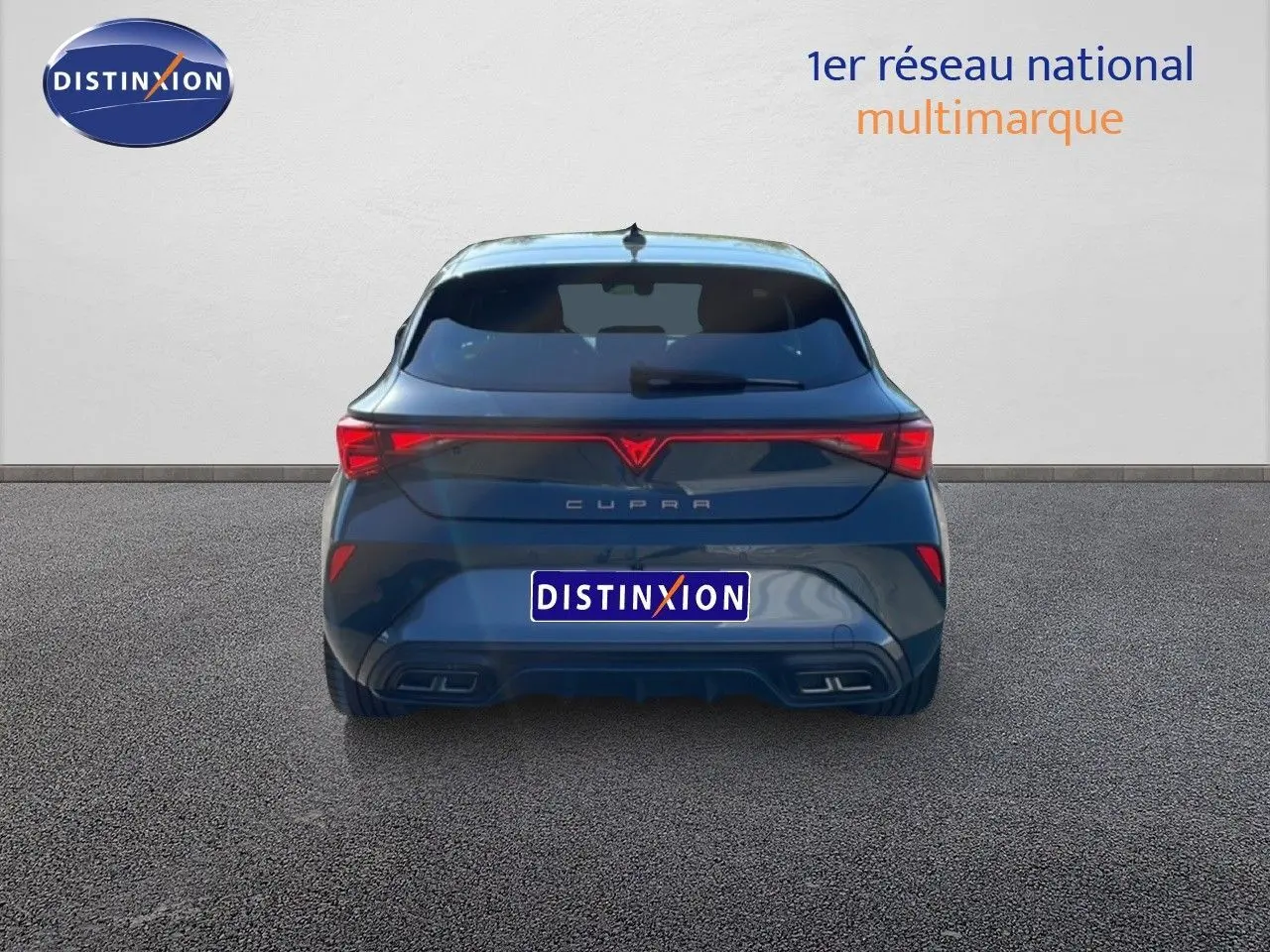 Vue arrière d'une CUPRA Leon 1.5 eTSI 150CH DSG en bleu Fjord avec feux LED et double sortie d'échappement intégrée.