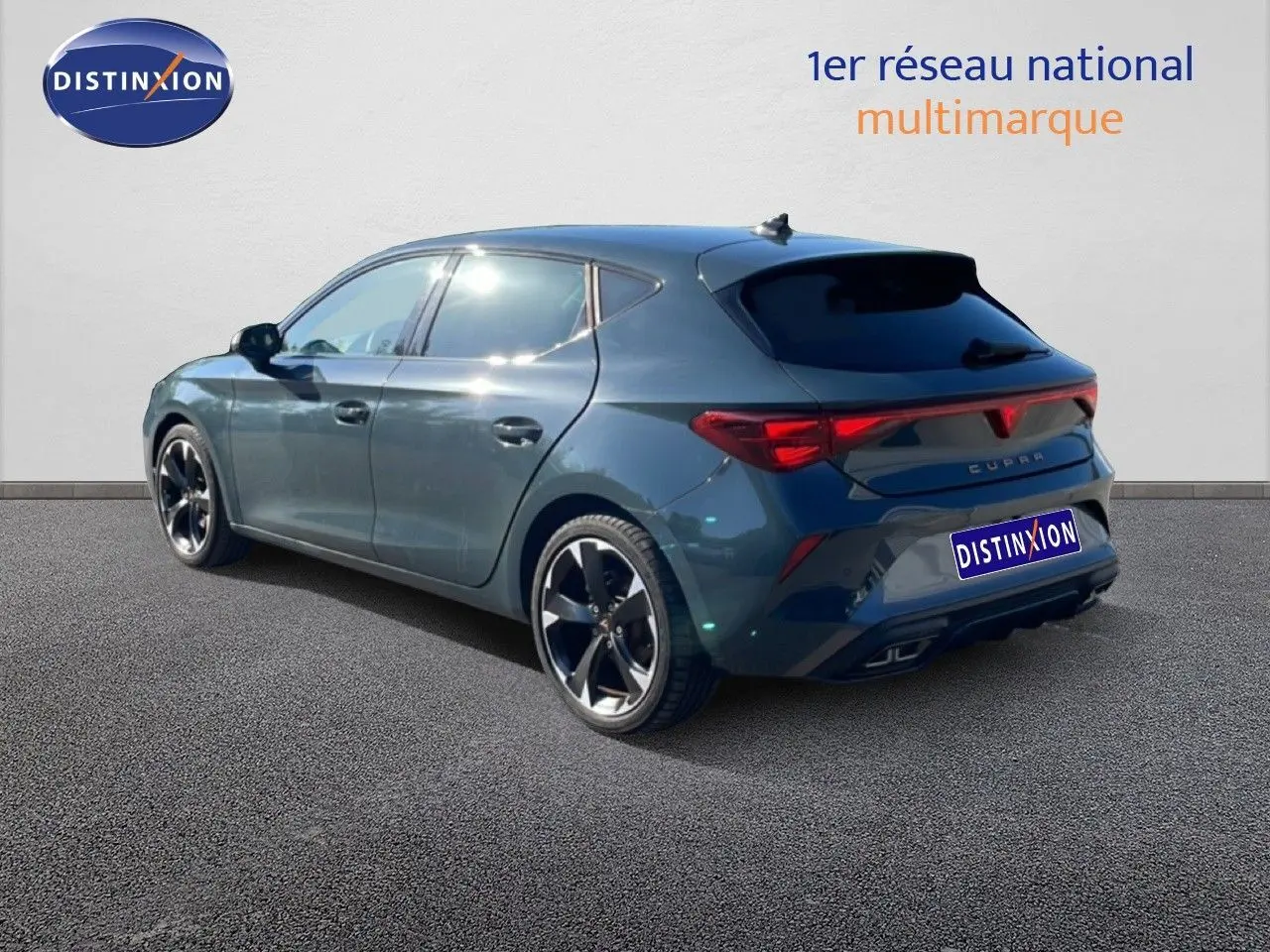 Vue 3/4 arrière droite d'une CUPRA Leon 2025 bleu Fjord avec jantes noires et feux arrière LED allumés.