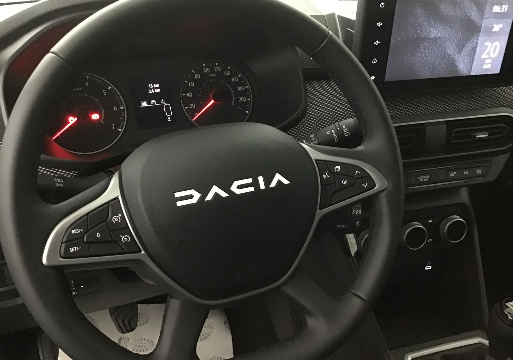 Vue rapprochée du volant noir de la Dacia Sandero Stepway 2025 avec tableau de bord et écran tactile visible.