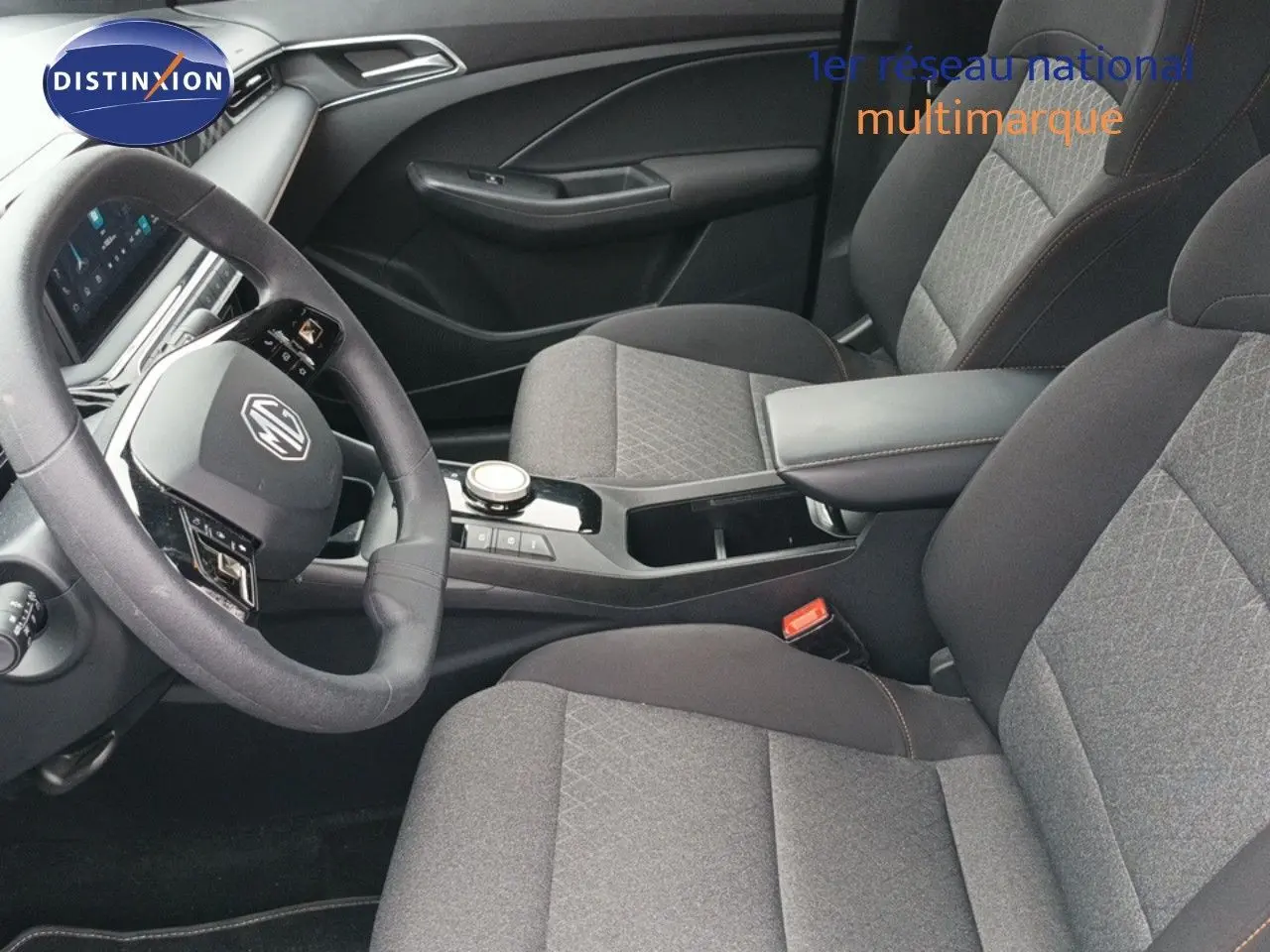 Vue intérieure côté conducteur du MG3 Hybrid+ Standard 2024 gris, avec volant multifonction et accoudoir central.