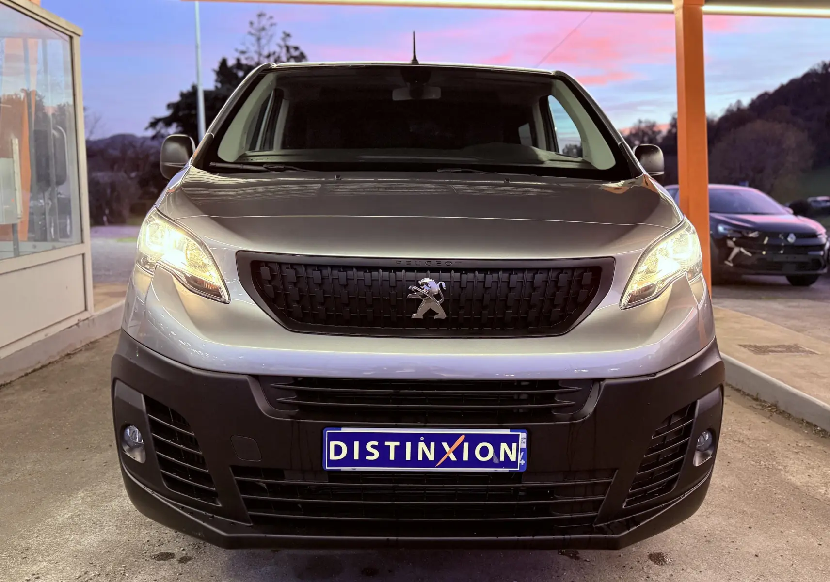 Vue frontale du Peugeot Expert Cabine Approfondie gris Artense métal avec phares allumés et calandre noire distinctive.