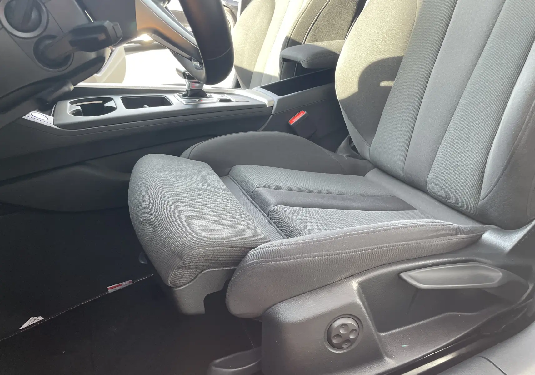 Gros plan sur le siège conducteur gris noir en tissu et la console centrale d'une Audi A4 Avant 40 TDI 2022.