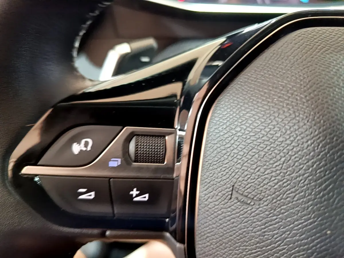 Gros plan sur les commandes vocales et volume au volant cuir du Peugeot 2008 PureTech 130 2021.