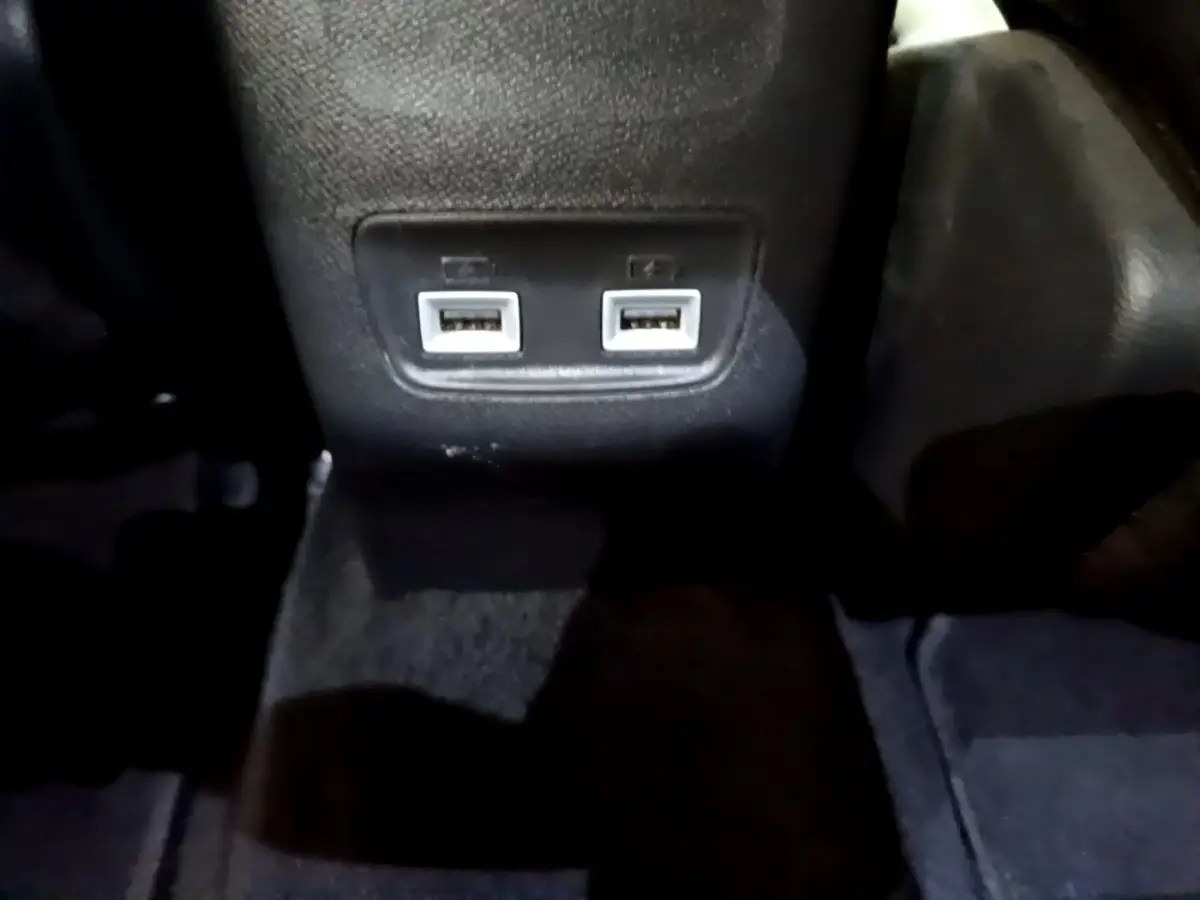 Gros plan sur les deux ports USB arrière intégrés au tunnel central du Peugeot 2008 PureTech 130 orange de 2021.