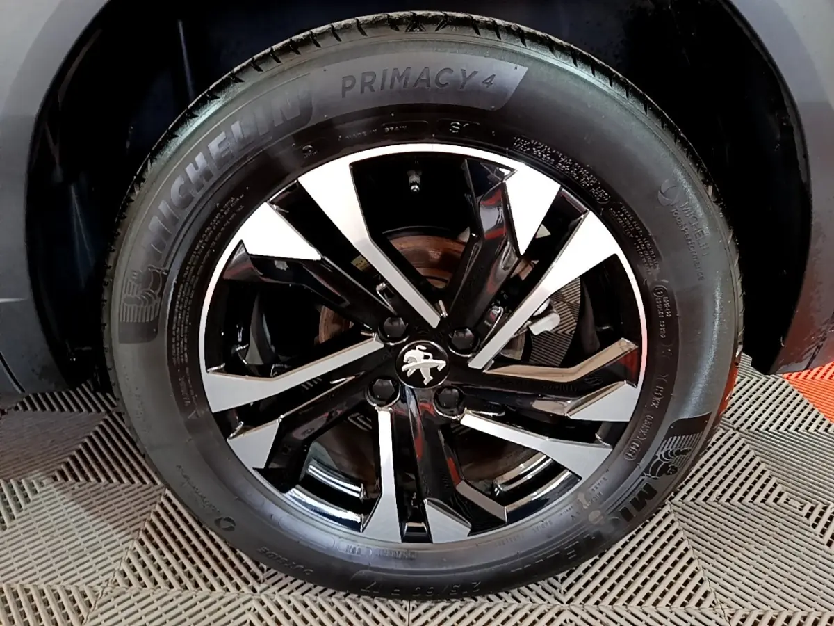 Gros plan sur la roue avant droite du Peugeot 2008 2021 avec jante alliage noire et argent et pneu Michelin Primacy 4.