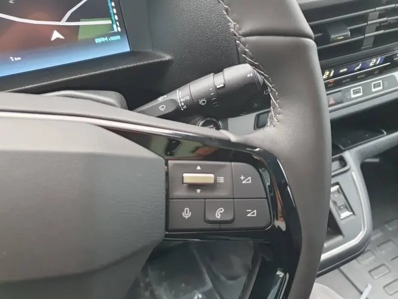 Gros plan sur le volant cuir noir du Citroën Jumpy gris Titane, avec commandes vocales et audio intégrées.