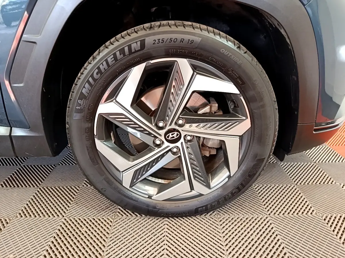 Gros plan sur la roue avant droite du Hyundai Tucson bleu 2023 avec jante alliage et pneu Michelin.