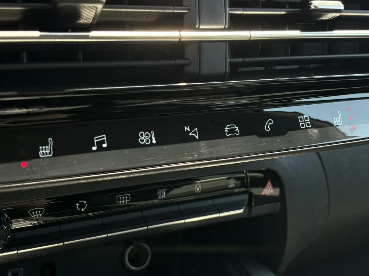 Vue rapprochée de la console centrale tactile noire du Citroën C5 Aircross Hybrid 2025 avec commandes de sièges chauffants et multimédia.