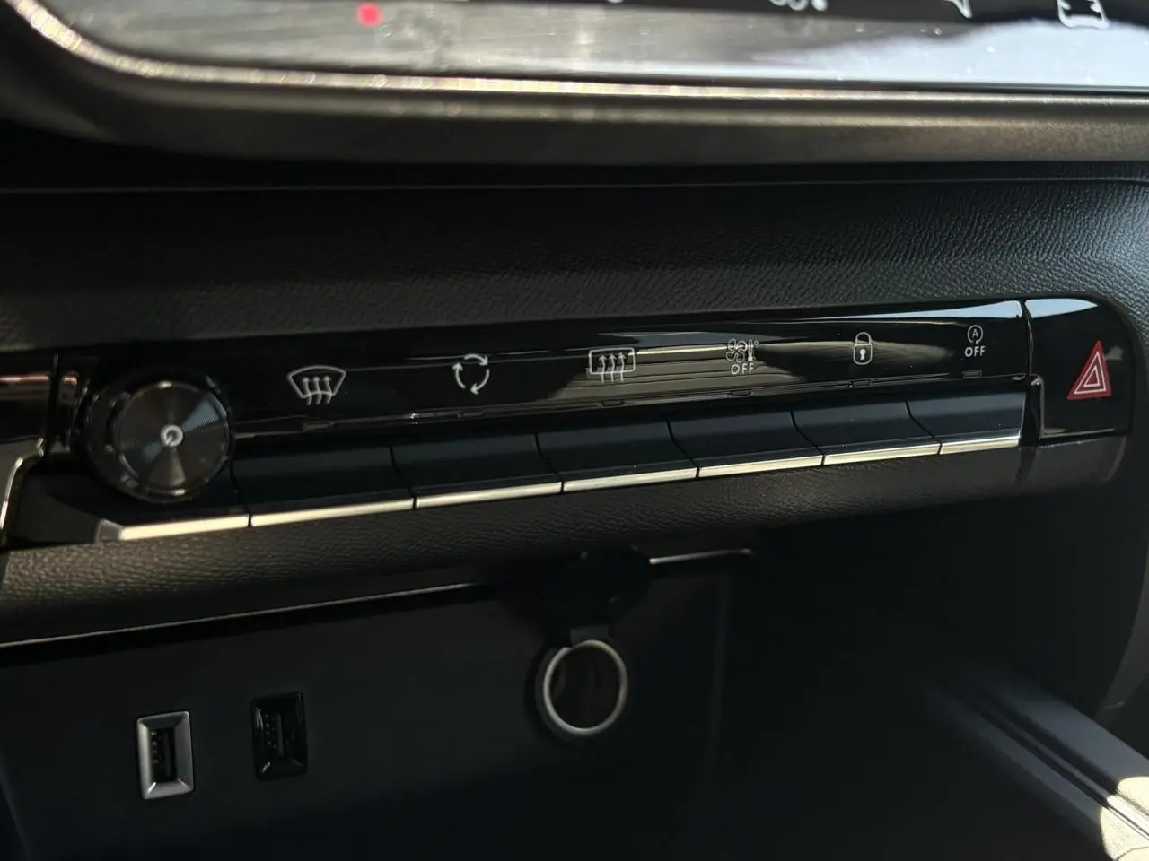 Gros plan sur la console centrale noire du Citroën C5 Aircross Hybrid avec boutons de commande et prises USB visibles.