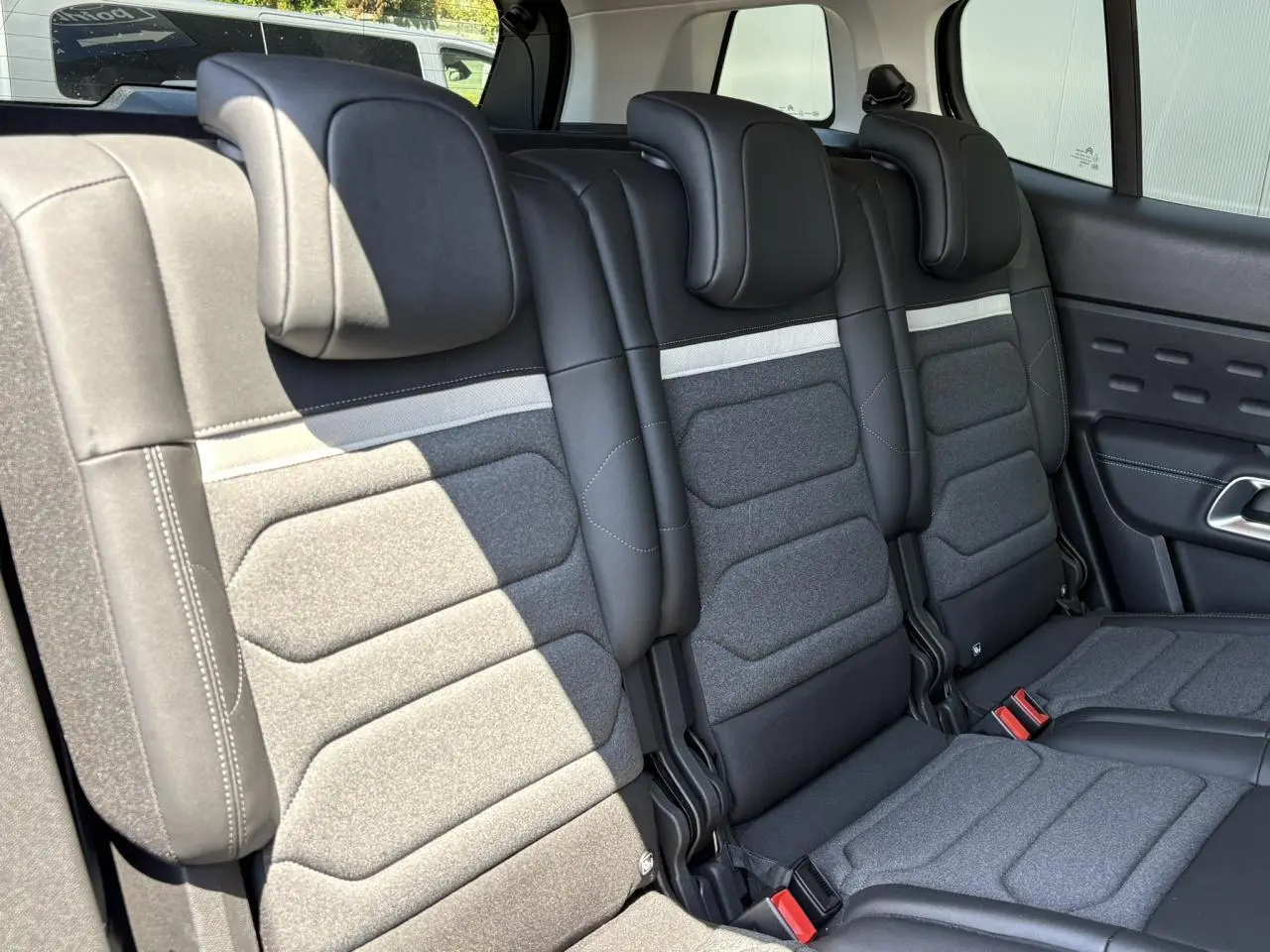 Vue intérieure des trois sièges arrière indépendants en tissu gris et noir du Citroën C5 Aircross Hybrid 2025.