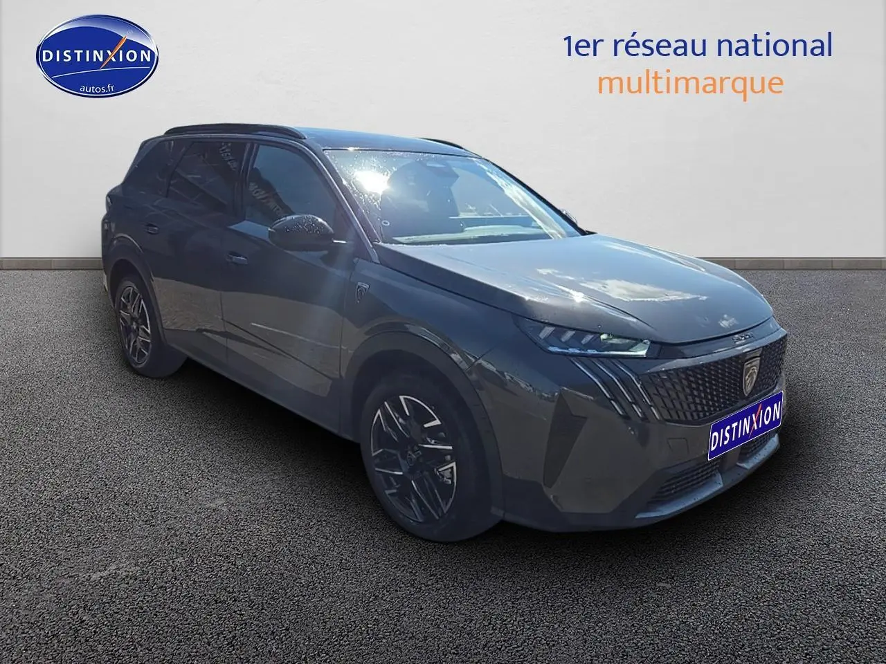 Peugeot 5008 Hybrid 145 GT gris titane en 3/4 avant droit avec calandre distinctive et jantes alu.