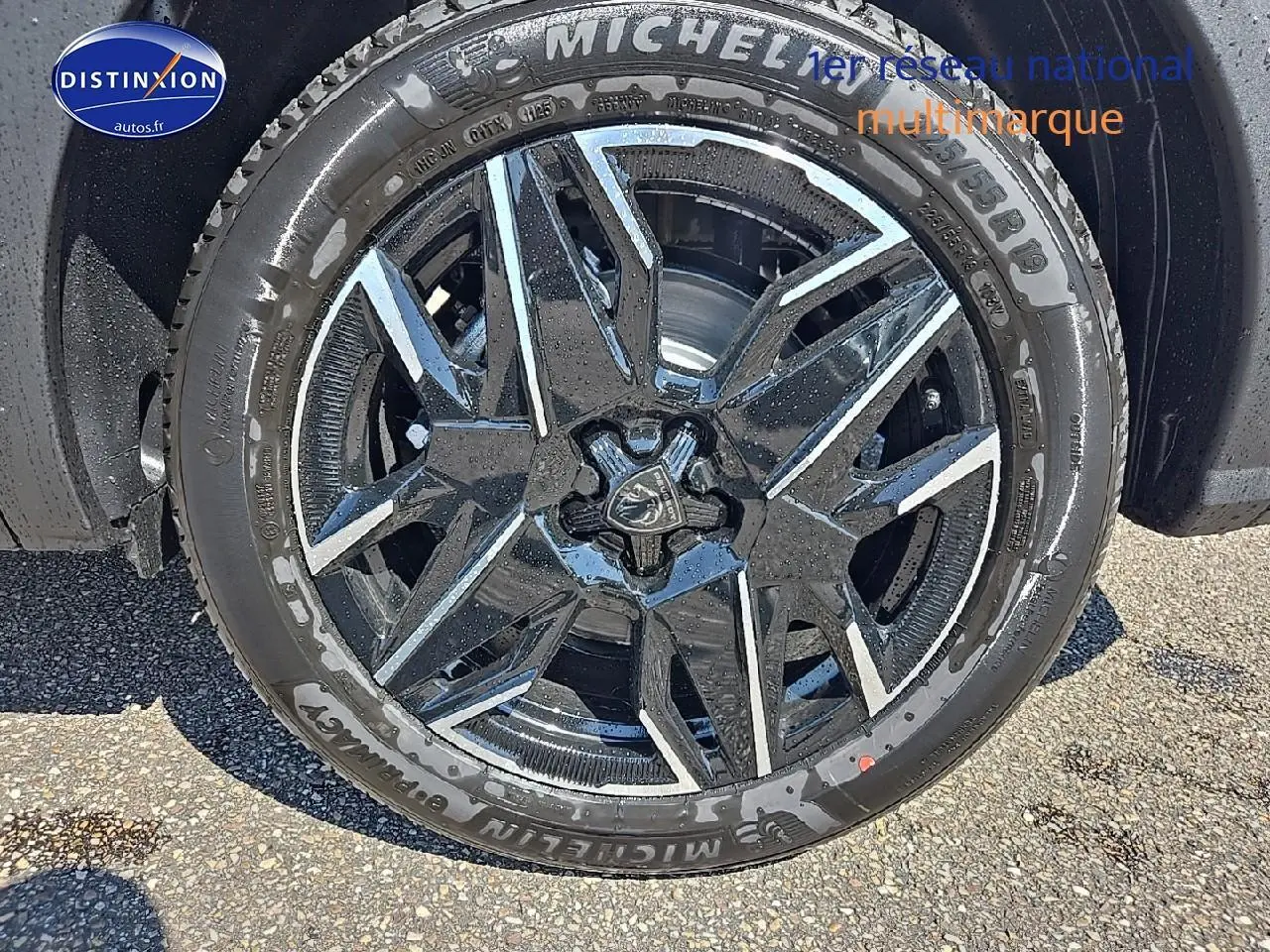 Gros plan sur la jante alu noire et argentée avec pneu Michelin du Peugeot 5008 Hybrid 145 gris titane.