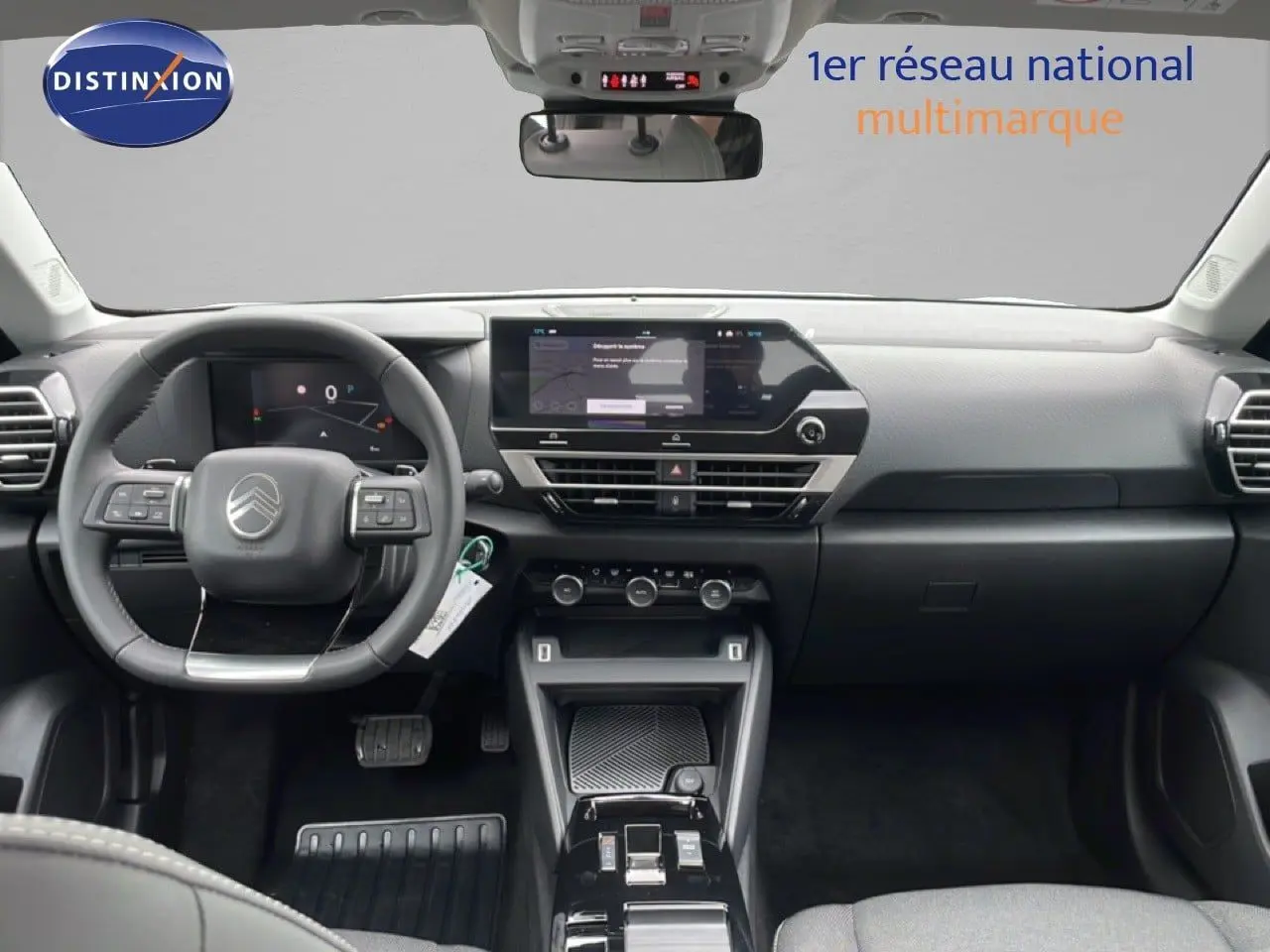 Vue intérieure frontale du tableau de bord noir et gris du Citroën C4 2026 avec écran tactile et volant multifonction.