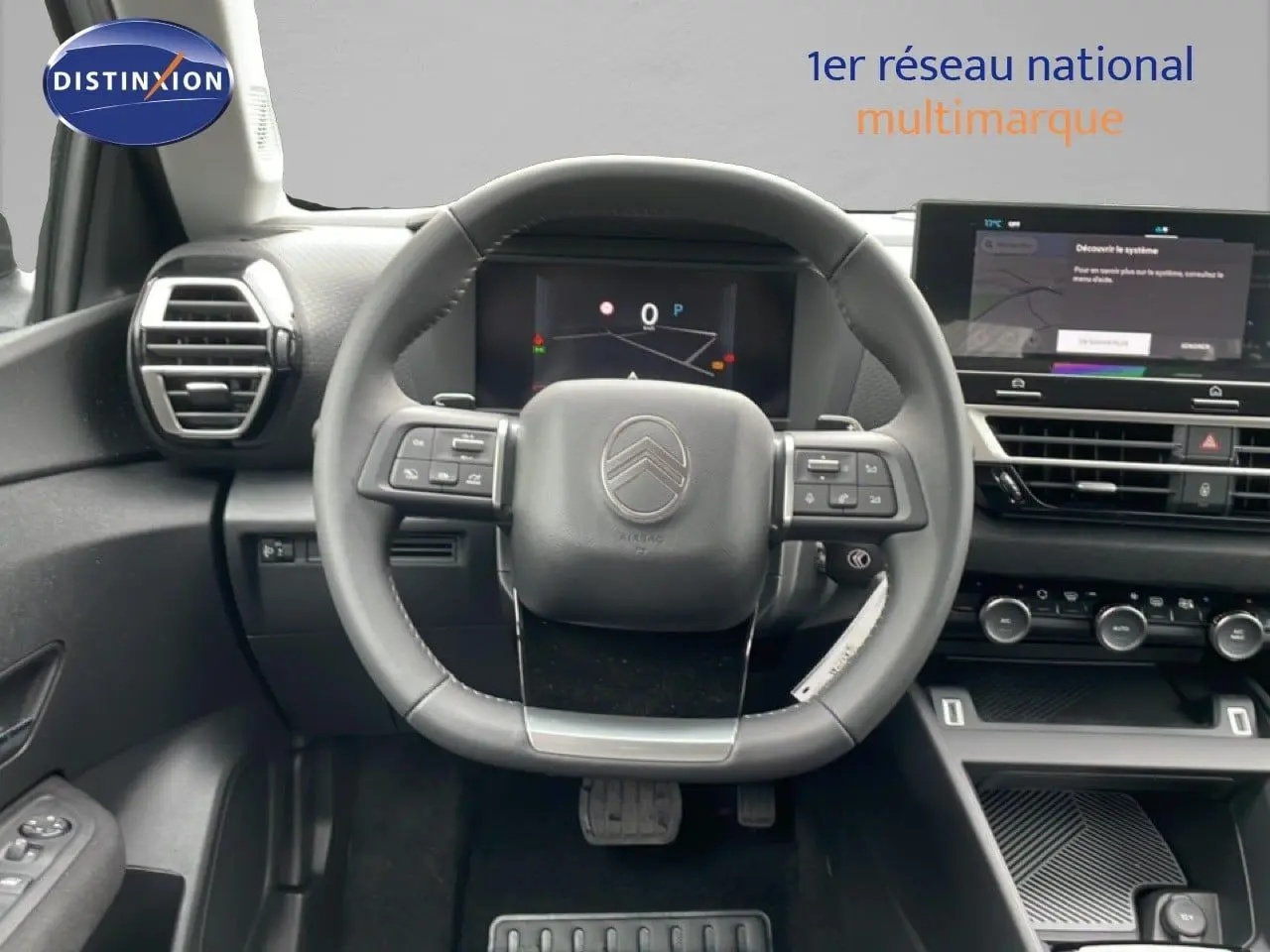 Vue intérieure centrée sur le volant noir du Citroën C4 2026 avec tableau de bord digital et écran tactile.
