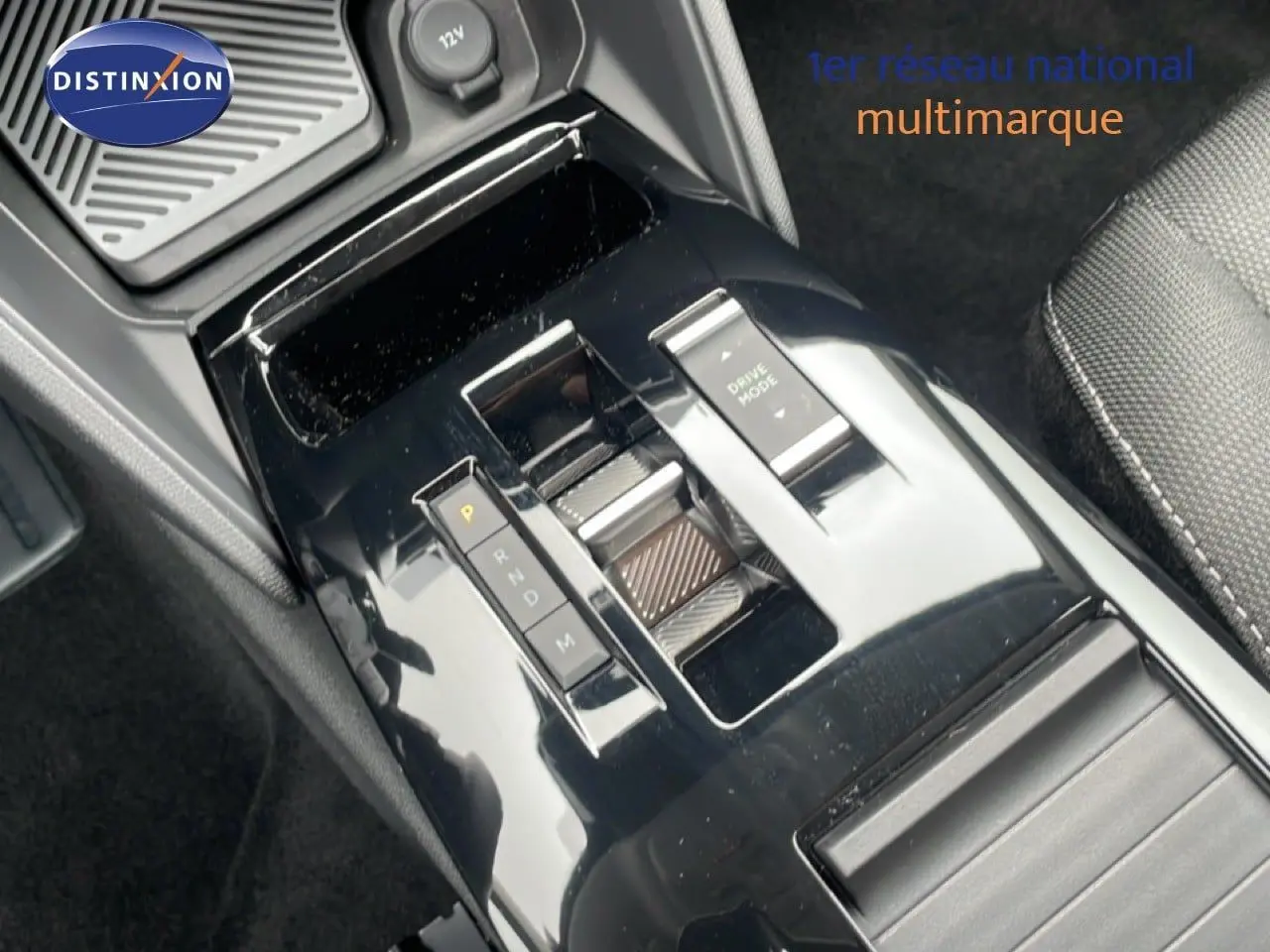 Gros plan sur la console centrale noire brillante de la Citroën C4 PureTech 130ch, montrant la commande de boîte auto et le sélecteur Drive Mode.