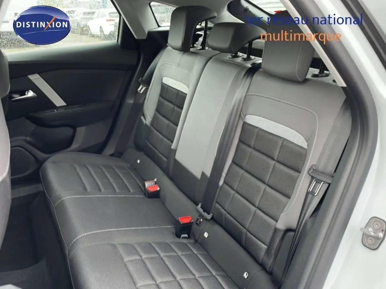 Vue intérieure du siège arrière côté droit d'une Citroën C4 blanc métal 2026, avec sellerie tissu noir matelassé.