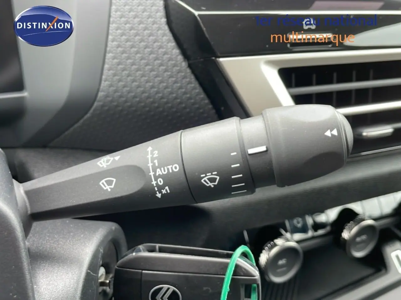 Gros plan sur la commande d’essuie-glace à gauche du volant dans l’habitacle noir du Citroën C4 blanc métal 2026.